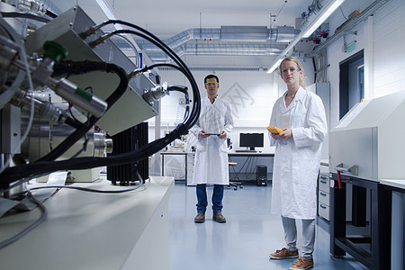 两名穿着实验室外套和安全眼镜的科学家站在实验室里图片
