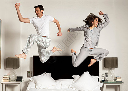 一对夫妇在床上跳跃图片