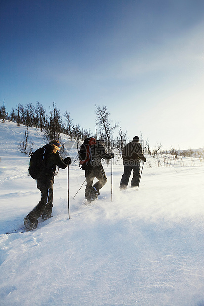 越野滑雪者在雪地里行走图片