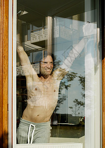 赤裸上身的男人站在窗口图片