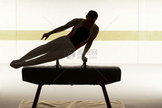 男子体操运动员在鞍马上表演图片