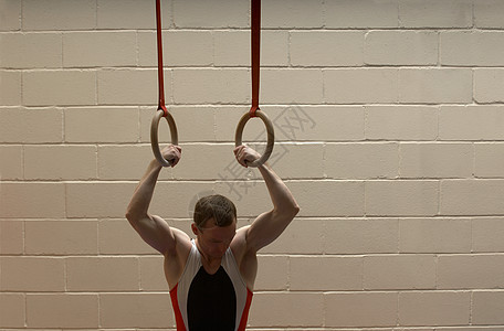从吊环上垂下的男子体操运动员高清图片