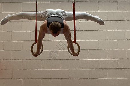 男子体操运动员在吊环上表演图片