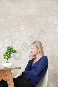 女人坐在盆栽前图片