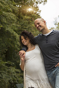 怀孕夫妇在公园散步图片