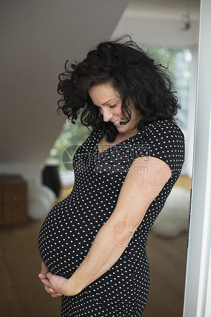 微笑着怀孕的中年妇女俯视的肖像