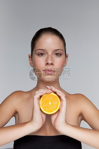 拿着一半橘子的女人图片