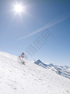 女人带着滑雪板上山图片