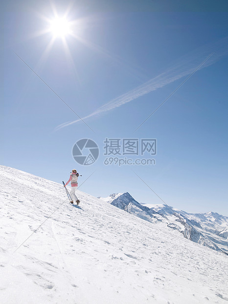 女人带着滑雪板上山图片