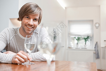厨房里有白葡萄酒的男人图片