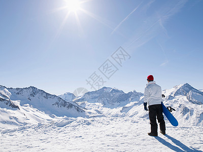 山顶上带着滑雪板的人背景图片