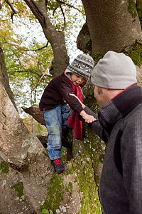 父亲在爬树时帮助儿子图片