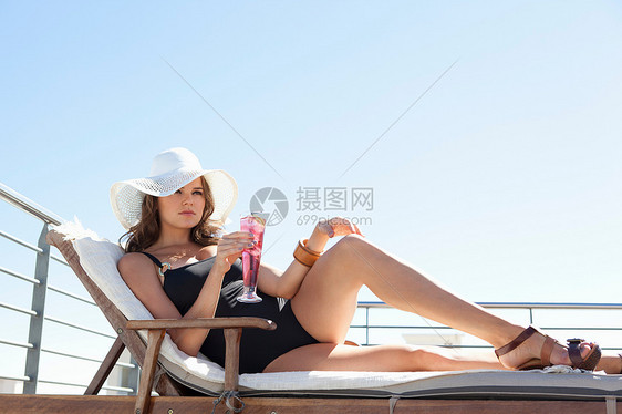 穿着泳衣的女人在草地椅子上放松图片