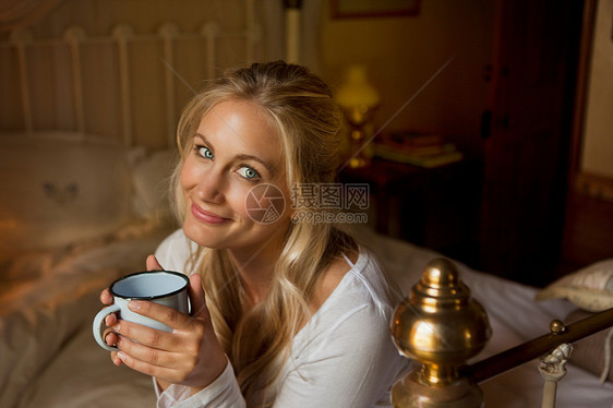 在床上喝咖啡的女人图片