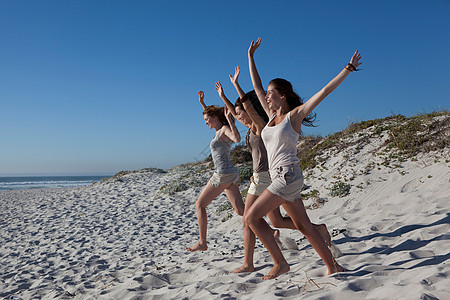 三个女孩从沙滩奔跑图片