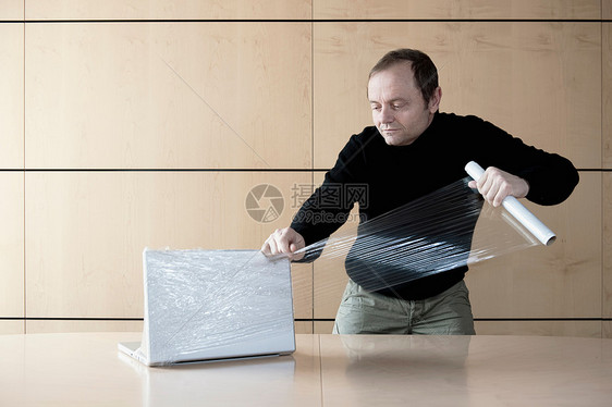 男人用塑料薄膜包装电脑图片