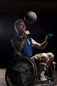 轮椅上带球的橄榄球运动员图片