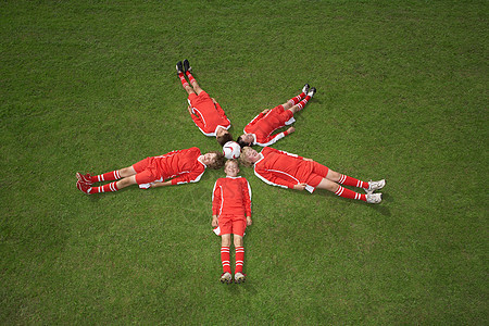 躺在球周围的足球运动员图片