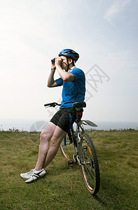 一个骑自行车的男人用望远镜看图片