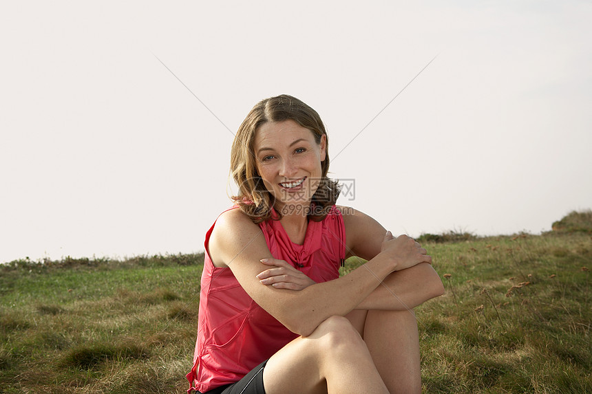 一个女人坐在草地上的肖像图片