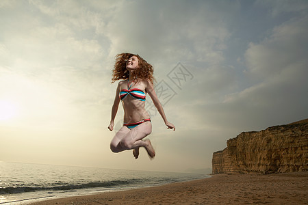 海滩上女子跳跃图片