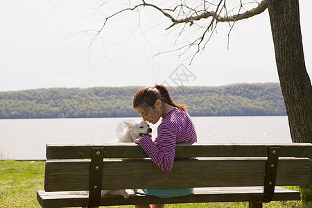 公园长椅上养狗的女人图片