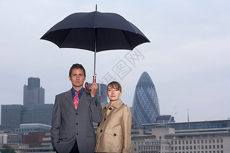 带雨伞城市景观的男人和女人图片