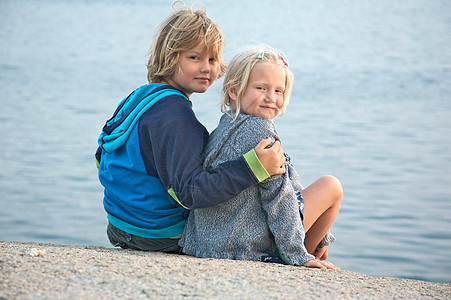 男孩和女孩坐在海边图片