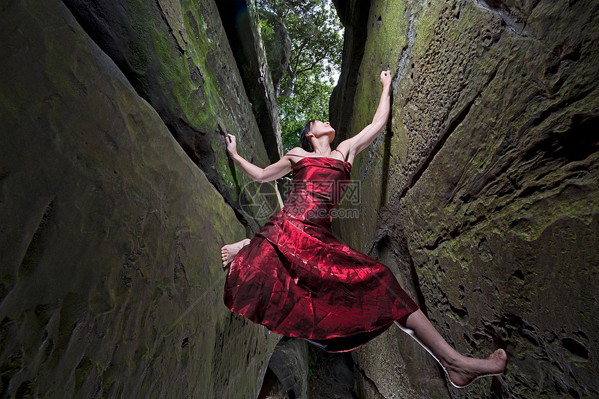 ‘~身着红色连衣裙的女子自由攀爬砂岩烟囱岩石缝隙  ~’ 的图片