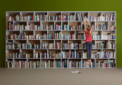 女孩跳到书架上找书图片