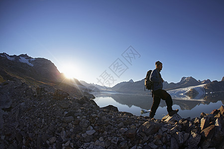 徒步旅行者沿着岩壁行走背景图片