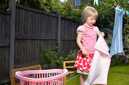 小女孩在花园里晾衣服图片