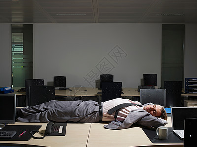 一个男人睡在他的书桌旁图片