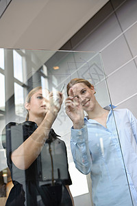 年轻的女商人在玻璃上写字图片