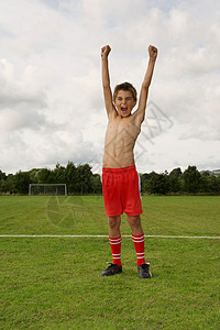 双臂高举的年轻足球运动员图片