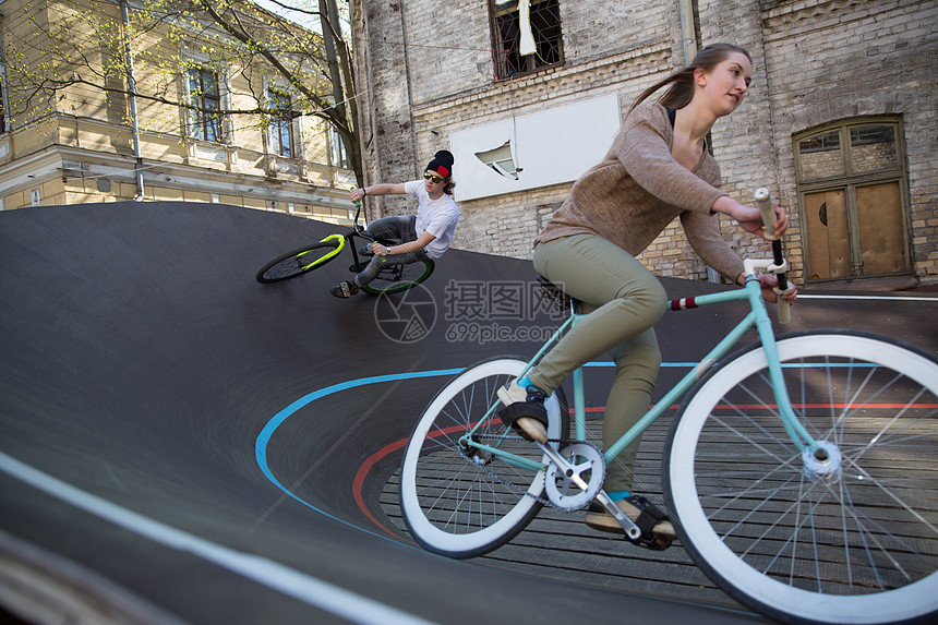 在拉脱维亚里加的城市赛车场，男子和女子骑自行车下山图片