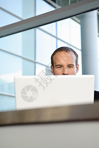 商人在笔记本电脑后面工作图片