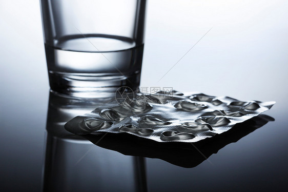 桌子上的药片和水杯图片