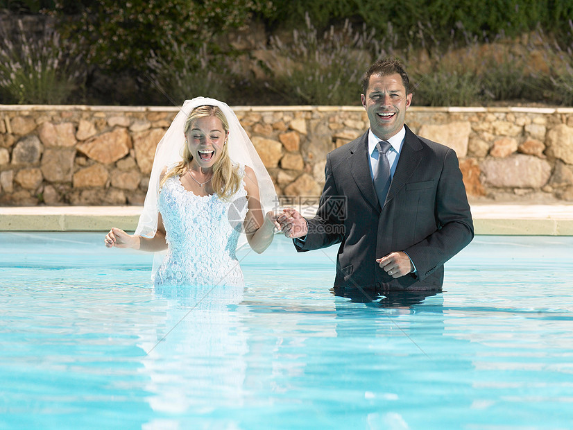 新娘和新郎站在游泳池里图片