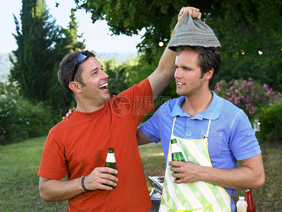 两个男人在烧烤时大笑图片