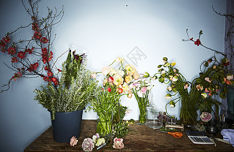 花店的桌子上有花瓶和花草图片