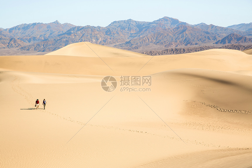 两个人走过美国加利福尼亚州死亡谷的沙地图片
