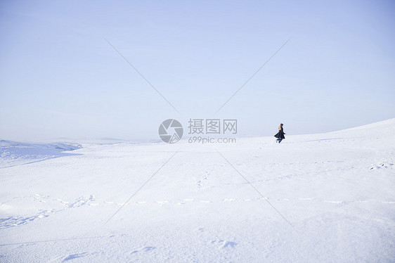 在雪景中行走的年轻女孩图片