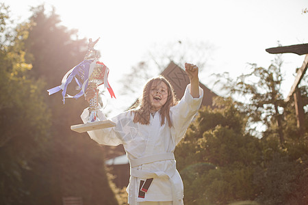 女孩手持奖杯庆祝获奖图片