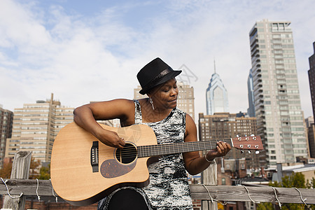 美国费城弹吉他的黑人女子背景图片