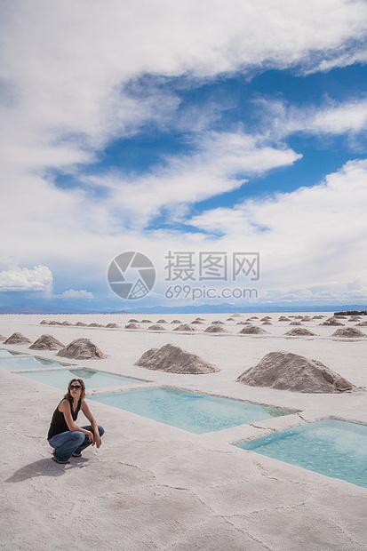 阿根廷科尔多瓦省萨利纳斯格兰德斯盐场的一位妇女坐在水池旁图片