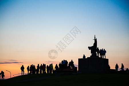 冰岛雷克雅未克日落时纪念碑周围人群的剪影图片