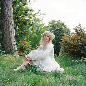 穿着白色连衣裙坐在草地上的女人图片