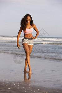年轻女子在沙滩上散步图片