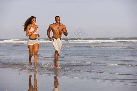 夫妻俩在海滩上奔跑图片